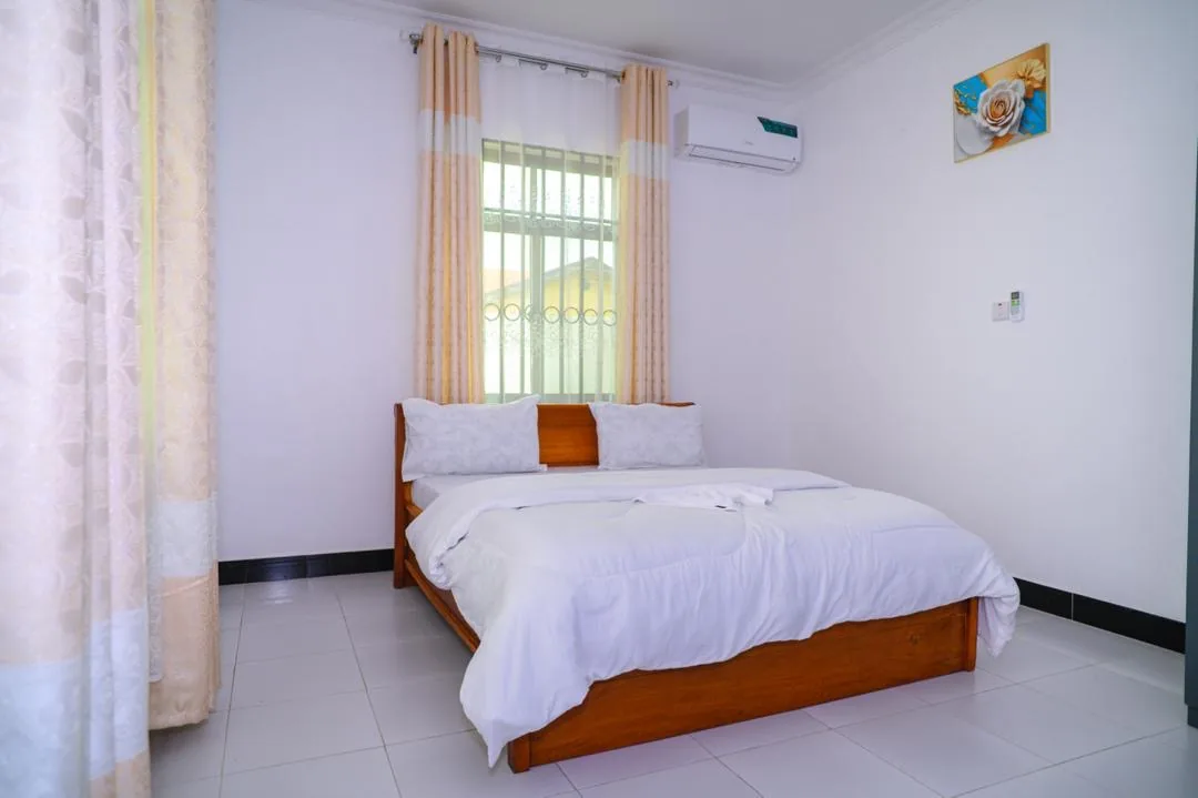 Double bed beside a curtained window