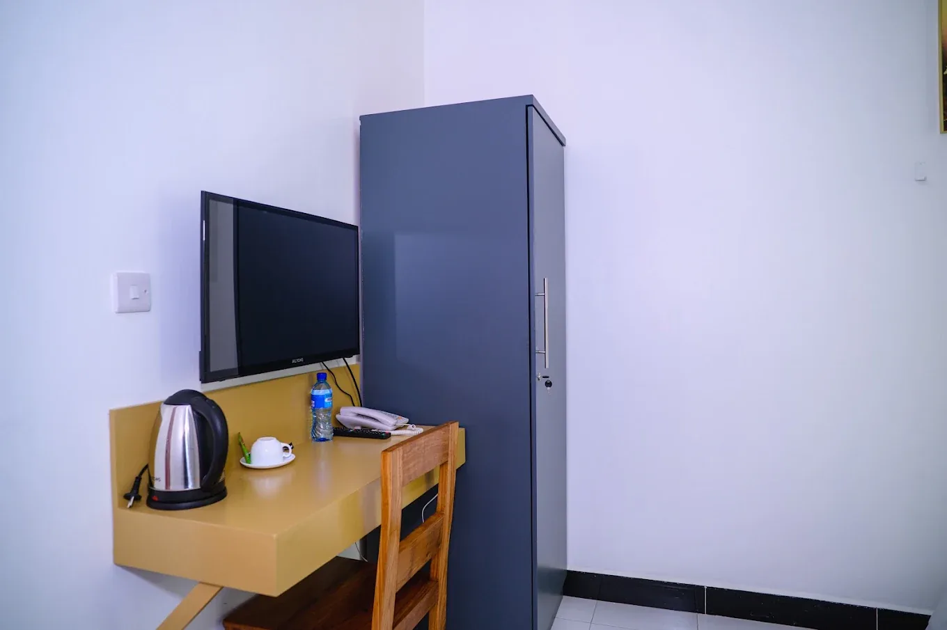 Desk, TV and wardrobe in a guest room